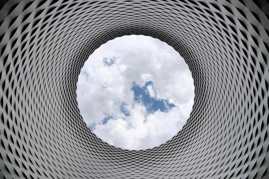 photo of the sky from inside a vertical tunnel